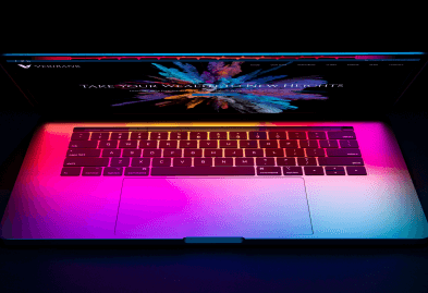 Closeup of a laptop lit with neon lights